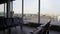 Empty seats of departure lounge at the airport, view of runway through window