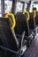 Empty seats with yellow handles in a minibus