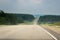 Empty Section Of Countryside Highway With Distant Traffic Of Cars, Trucks Before Summer Thunderstorm.