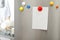 Empty sheet of paper with colorful magnets on refrigerator door in kitchen