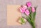 Empty sheet of paper and flowers. Gift box and note. Pink tulips and paper background