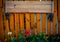 Empty signboard made of planks hanging on a wooden fence.