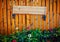 Empty signboard made of planks hanging on a wooden fence.