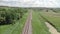 Empty single railroad in countryside. Drone flying over railway surrounded by forest and field. Cargo delivery. Transportation