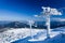 Empty ski lift covered with frost and snow with mountains at background