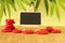 empty slate in width to write a message that is posed on an easel with red stones columns stones on floor and in zen lifes