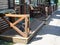 Empty small outdoor cafe and bistro with wooden rustic style furniture on a side street in Bucharest on a summer morning