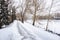Empty Snow Covered Riverside Path Lined with Leafless Trees