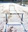 Empty snowy running track with hurdles