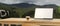 Empty space on wooden worktable with laptop mockup and coffee cup over mountain view in the background