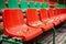 Empty sports grandstand in the leaves in the fall. Yellow leaves lie on a seat of a tribune.