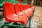 Empty sports grandstand in the leaves in the fall. Yellow leaves lie on a seat of a tribune