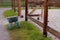 The empty stable. Empty open paddock for horse riding. Wheelbarrow for manure near an empty stable.