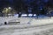 Empty stone causeway, bench and white snow in park at winter