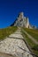 Empty stone trail leads up towards the towering mountaintop in the Dolomites.