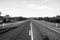 Empty straight asphalt road through Australian outback. Black and white image