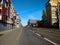 Empty straight highway surrounded by modern style apartment buildings going towards office buildings