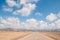 Empty straight road on a desert and blue scattered clouds sky