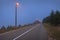 Empty straight road in mountain forest at spooky dusk