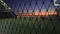 Empty Street Basketball court at night through mesh wire fence in 4k