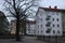 Empty street. Four-storey bright houses with a red roof. Suburb. A deserted yard. Early spring or late autumn.