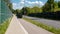 An empty street, pavement and bicycle path separated by noise barriers