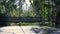 Empty summer house with long bench and tropical plants and trees around.