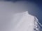 Empty summit ridge of a high alpine peak during bad weather