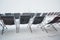 Empty sun lounger chairs out on a terrace during a Winter whiteout blizzard , Les Sybelles, France