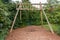 Empty swing on children playground. Children swing in the park,wooden swing, wooden swing on the lawn