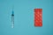 Empty syringe and orange pills package on the turquoise surface.