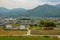 Empty T-intersection at road next to small country village with mountains in background