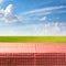 Empty table covered with checked tablecloth over green meadow and blue sky