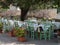 Empty Tables Set for Outdoor Lunch under an Olive Tree in a Tuscan Village in Italy