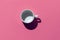 Empty tea cup on pink paper background. Coffee mug from above. Minimal concept Hard deep shadow. Flat lay, top view