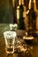 An empty tequila glass, with salt at the edges, stands on the bar, in the background are different bottles of alcohol