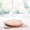 Empty textured wooden pizza board with napkin on the table and kitchen window blurred background