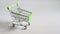 Empty toy metal super market trolley miniature shopping cart of green color.