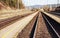 Empty train station in small city on sunny day, shallow depth of field photo, focus on concrete platform and steel rails