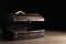 Empty treasure chest on wooden table against black background. Space for text