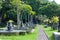 Empty tropical palm alley with fountains and exotic plants, stairs and sculptures in Bali, Asia