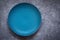 Empty turquoise ceramic plate On a concrete background. Top view