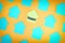 Empty turquoise stickers on an orange background lie diagonally. Photo with a vignette. In the center there is a yellow