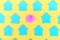 Empty turquoise stickers in the shape of a house, on a bright yellow background. In the center is a pink sticker in the
