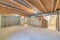 Empty unfinished large basement with concrete flooring and wooden frames