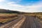 Empty unpaved road in a barren rolling landscape