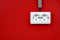 Empty, unplugged european wall outlet close up on red background. White electric socket on the red wall. Closeup