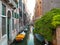 Empty Venice canal with boats moored near the building walls