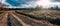 Empty village road going into the distance, off-road, sunset rays of the sun