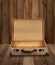 Empty vintage suitcase wooden plank background